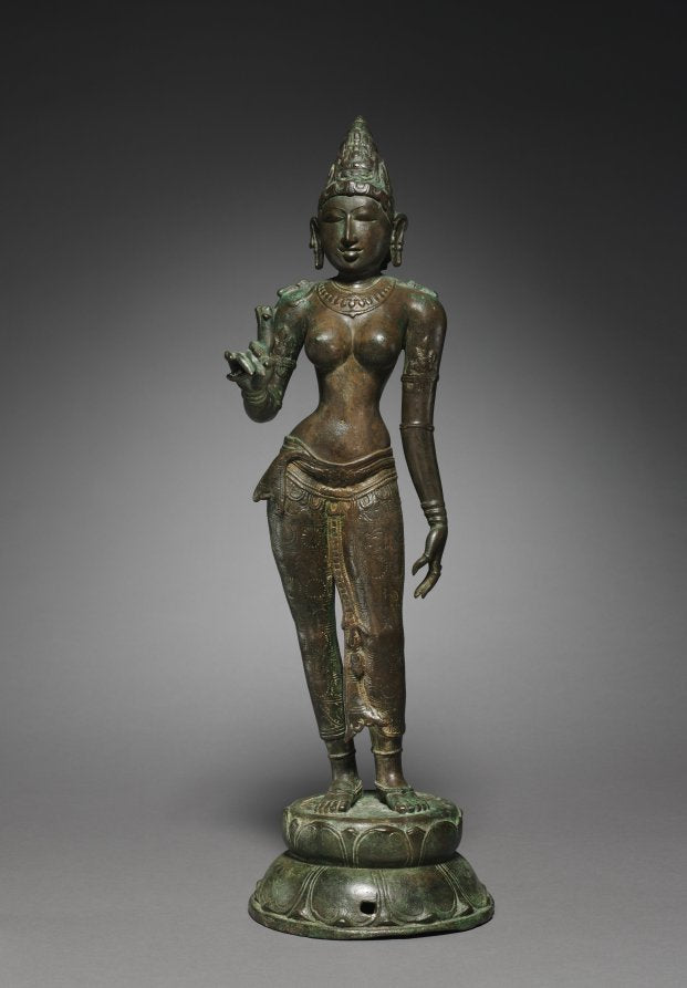 Chola bronze goddess standing gracefully and holding a lotus flower