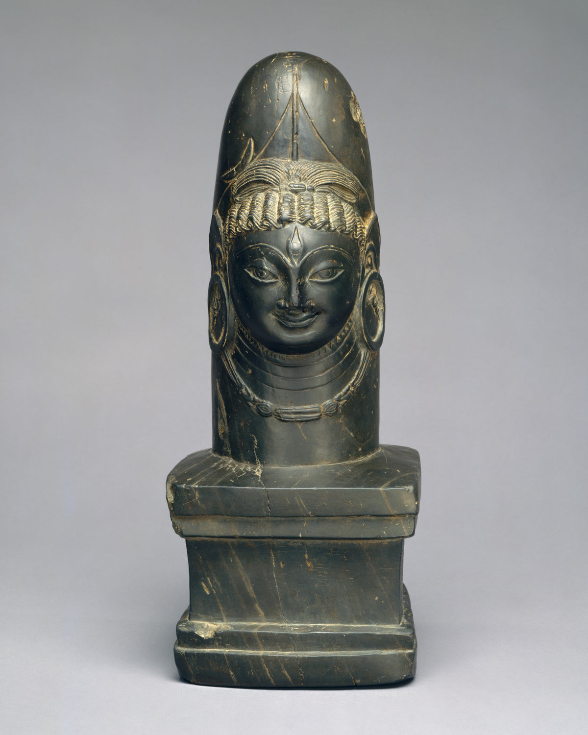 Stone Shiva linga with one carved face of Shiva
