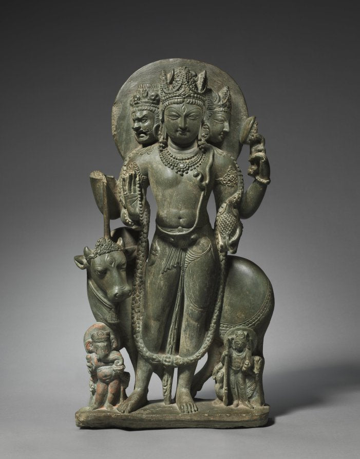 Standing Shiva sculpture with multiple arms and identifying divine attributes